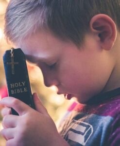 child praying with bible